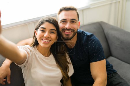 Photo for Personal perspective of an attractive couple taking a selfie together while relaxing at home - Royalty Free Image