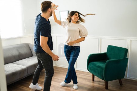 Photo for Beautiful cheerful woman dancing with her partner and feeling happy about moving into their new home - Royalty Free Image