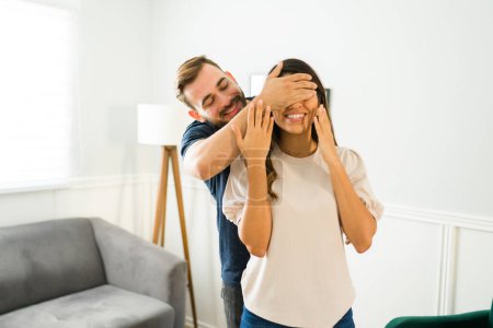 Téléchargez les photos : Homme attrayant couvrant les yeux de sa fiancée et la surprenant avec une nouvelle maison - en image libre de droit