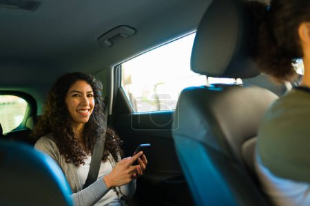 Téléchargez les photos : Jeune passagère faisant un voyage avec un chauffeur d'une application de covoiturage - en image libre de droit
