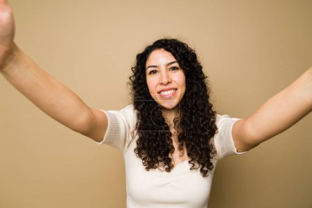 Photo for Personal perspective of a happy latin woman taking a selfie and smiling to post on social media - Royalty Free Image