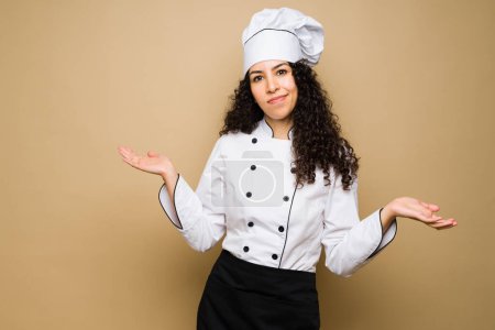 Téléchargez les photos : Doubtful woman chef looking uncertain after a question while having doubts about a question - en image libre de droit