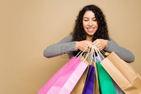 Foto de Beautiful latin young woman having fun going shopping and buying gifts while holding a lot of shopping bags - Imagen libre de derechos