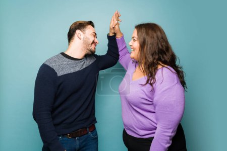 Téléchargez les photos : Beautiful happy couple making a high five and celebrating while laughing and having fun on a date - en image libre de droit