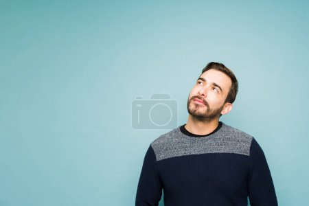 Photo for Thoughtful smart man looking up while thinking about a new idea and using his imagination - Royalty Free Image