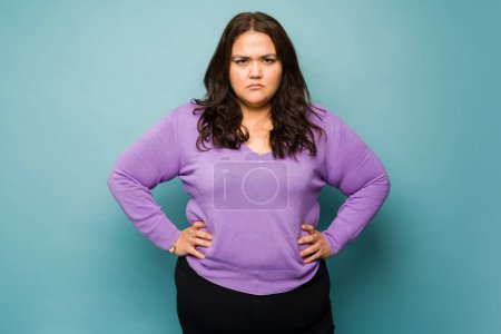 Foto de Angry annoyed obese woman looking frustrated while having problems making eye contact - Imagen libre de derechos