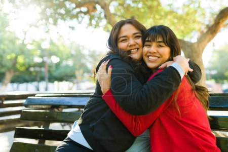 Foto de Beautiful cheerful women best friends hugging having a fun time together at the park - Imagen libre de derechos