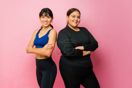 Téléchargez les photos : Active young women friends with activewear smiling looking happy about exercising together - en image libre de droit