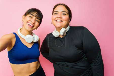 Foto de Beautiful happy women best friends taking a selfie together after doing an active workout - Imagen libre de derechos