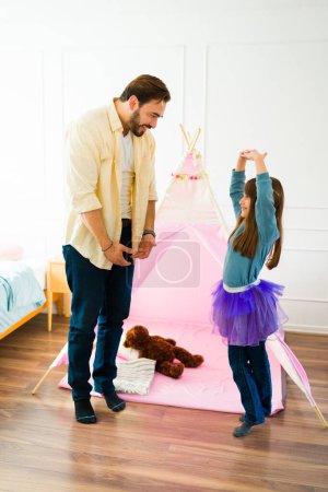 Photo for Adorable little girl dressed as a princess and happy father dancing ballet together while playing - Royalty Free Image