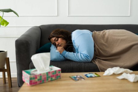 Téléchargez les photos : Triste femme obèse allongée sur le canapé avec une couverture se sentant fatiguée de pleurer l'air déprimé après avoir rompu avec son petit ami - en image libre de droit