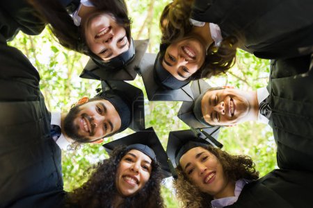 Téléchargez les photos : Portrait d'amis heureux souriants s'amusant et prenant des photos ensemble lors de leur cérémonie de remise des diplômes universitaires - en image libre de droit