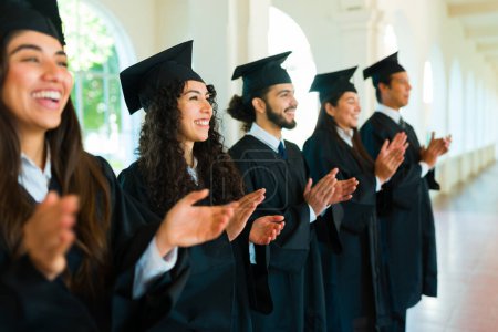 Photo for Excited graduates at the graduation ceremony feeling happy clapping excited celebrating getting their university diploma - Royalty Free Image