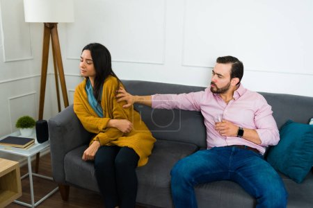 Photo for Drunk caucasian man drinking alcohol and trying to talk with his angry sad wife while having marriage problems because of addiction - Royalty Free Image