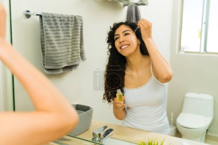 Téléchargez les photos : Belle femme excitée mettant de l'huile d'acide hyaluronique et des produits de soin de la peau pour une peau lisse - en image libre de droit