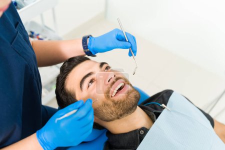 Téléchargez les photos : Vue de dessus d'un homme séduisant patient venant chez le dentiste pour un examen dentaire de vérification des cavités - en image libre de droit