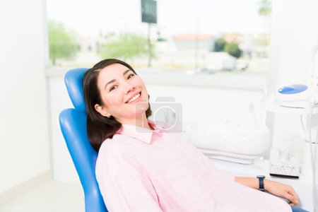 Photo for Gorgeous caucasian woman and patient smiling with white healthy teeth waiting for the dentist for an examination - Royalty Free Image