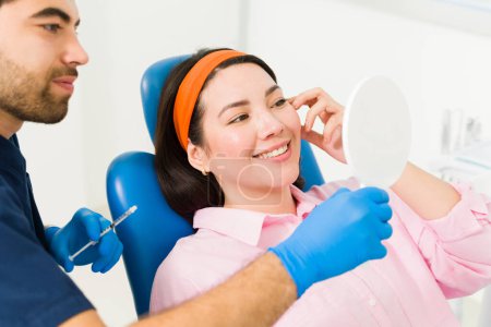 Foto de Mujer joven emocionada sonriendo sintiéndose feliz por los resultados del procedimiento cosmético en la clínica de belleza - Imagen libre de derechos