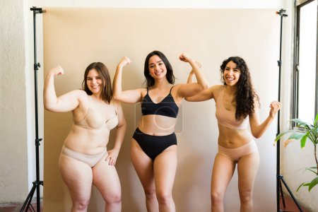 Téléchargez les photos : Les jeunes femmes souriantes avec des corps divers regardant forte favorisant la positivité du corps et l'acceptation dans leurs sous-vêtements - en image libre de droit