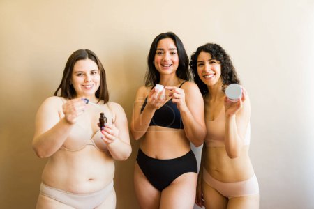 Photo for Portrait of beautiful diverse young women in underwear promoting body positivity and acceptance using skin care products - Royalty Free Image
