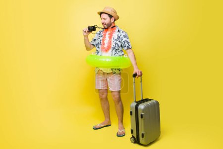 Foto de Hombre caucásico que parece un turista tomando fotos con una cámara durante sus vacaciones de verano viajando a la playa - Imagen libre de derechos