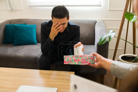 Téléchargez les photos : Homme déprimé en deuil parlant de son chagrin et pleurant après la mort de son partenaire ou ami pendant la thérapie - en image libre de droit