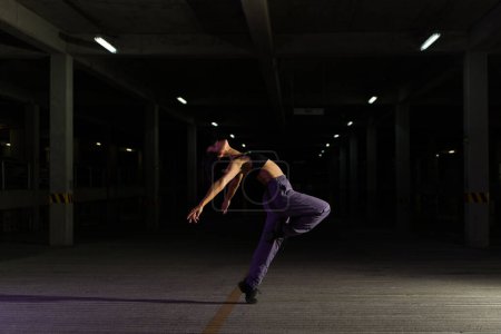 Téléchargez les photos : Artistique cool belle danseuse dansant dans la rue tout en faisant une danse cool dramatique - en image libre de droit