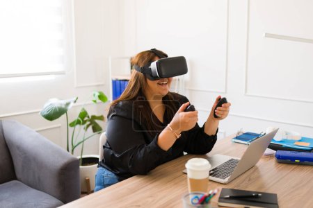 Téléchargez les photos : Femme d'affaires excitée gestionnaire utilisant des lunettes de réalité virtuelle et de la technologie tout en travaillant dans le bureau - en image libre de droit