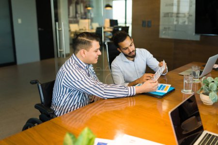 Foto de Dos personas de negocios mirando gráficos durante la reunión en la sala de juntas de la oficina de inicio - Imagen libre de derechos