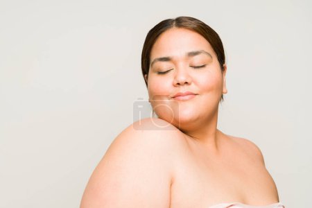 Foto de Mujer gorda atractiva feliz sonriendo y buscando relajado con mucha confianza en sí mismo durante un concepto de belleza con espacio de copia - Imagen libre de derechos