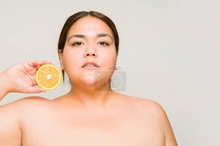 Photo for Gorgeous big woman with self love and confidence using vitamin c and skin care beauty products with copy space - Royalty Free Image