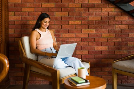 Téléchargez les photos : Belle femme heureuse souriante et amusante tout en utilisant la zone wifi et ordinateur portable dans un beau café - en image libre de droit