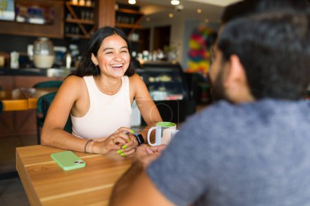 Téléchargez les photos : Belle femme excitée rire et s'amuser lors d'un rendez-vous café avec son ami - en image libre de droit