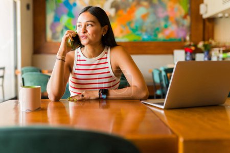 Foto de Mujer joven inteligente hablando con un cliente usando un auricular mientras trabaja como agente representante de ventas con una computadora portátil - Imagen libre de derechos