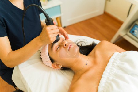 Téléchargez les photos : Femme séduisante détendue au spa de bien-être de beauté et ayant un traitement hydro-facial pour une belle peau - en image libre de droit