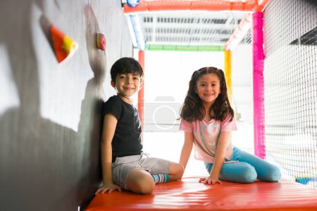 Foto de Sonriendo adorables niños mirando felices en el patio interior jugando con amigos y divirtiéndose con juegos - Imagen libre de derechos