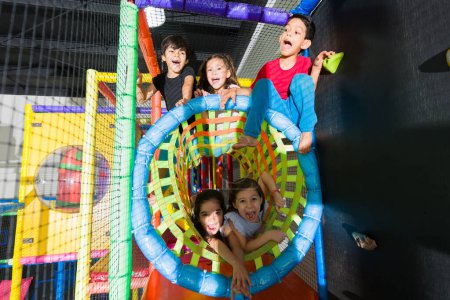 Photo for Happy group of children looking excited while playing together as friends in the fun indoor playground and laughing - Royalty Free Image