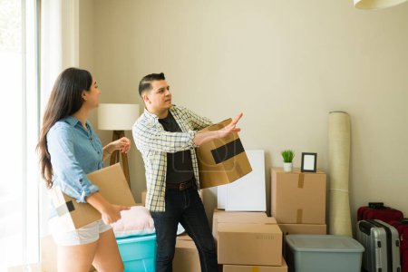 Téléchargez les photos : Mariés hispaniques portant des boîtes en carton et déballer dans leur nouvelle maison ou appartement après avoir obtenu une hypothèque - en image libre de droit
