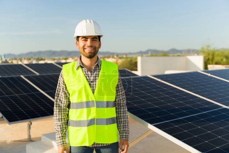Photo for Happy engineer worker smiling after installing solar panels and photovoltaic cells in the rooftop of a house - Royalty Free Image