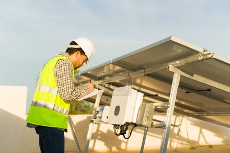 Photo for Engineer worker working installing solar panels and photovoltaic inverter for clean energy generation - Royalty Free Image