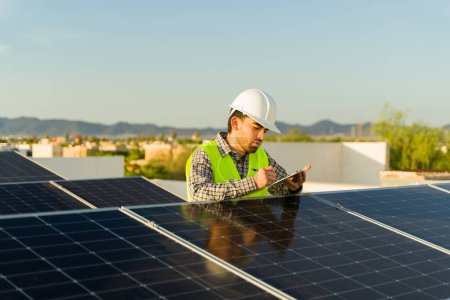 Foto de Instalador de ingenieros que trabaja en la instalación de paneles solares en una casa residencial mientras comprueba las celdas fotovoltaicas - Imagen libre de derechos