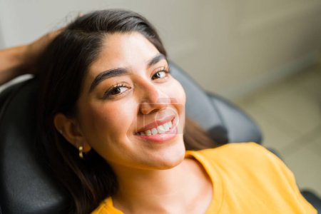 Téléchargez les photos : Portrait d'une belle femme latine heureuse souriante regardant la caméra tout en ayant un nouveau design de sourcil dans le salon de beauté - en image libre de droit