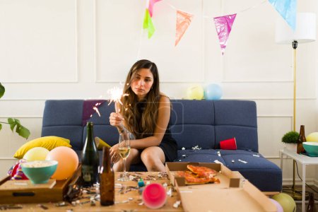 Foto de Triste mujer molesta con una chispeante sensación de soledad y resaca después de despertar de una noche bebiendo alcohol durante una fiesta en casa - Imagen libre de derechos