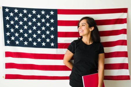 Téléchargez les photos : Joyeux beau femme pointant vers le drapeau américain se sentant patriote sur le rêve américain apprendre et étudier les leçons d'anglais - en image libre de droit