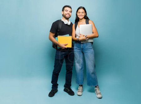 Téléchargez les photos : Portrait d'un étudiant heureux attrayant et des partenaires d'étude portant leurs livres et souriant prêt pour l'université - en image libre de droit