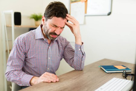 Téléchargez les photos : Patron malade ou homme d'affaires souffrant d'un mal de tête et regardant stressé avec beaucoup de travail au bureau - en image libre de droit