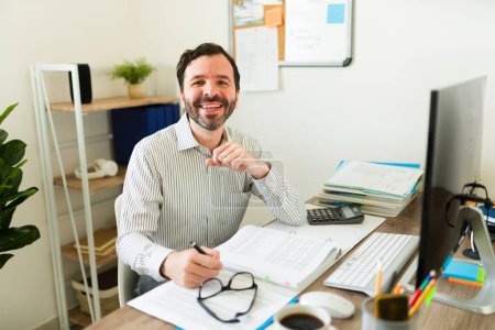 Téléchargez les photos : Portrait d'un heureux comptable souriant tout en faisant des finances d'affaires et en travaillant au bureau - en image libre de droit