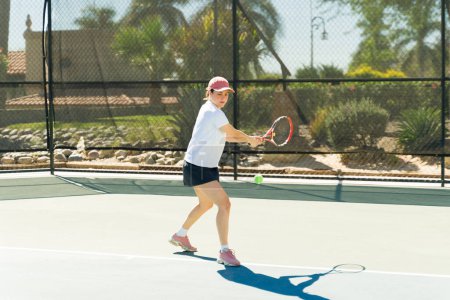 Téléchargez les photos : Femme séduisante sportive s'entraînant sur le court de tennis et jouant un match pendant un match de tennis en plein air - en image libre de droit