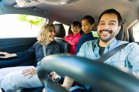Téléchargez les photos : Belle famille caucasienne heureuse souriant aller sur une route amusante et conduire la voiture en s'amusant ensemble - en image libre de droit