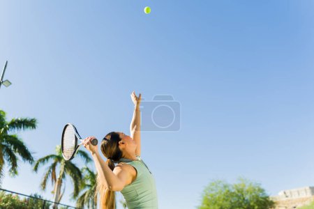 Foto de Deportiva mujer activa practicando su tenis servir y hacer ejercicio jugando al tenis mientras se divierten con una raqueta - Imagen libre de derechos